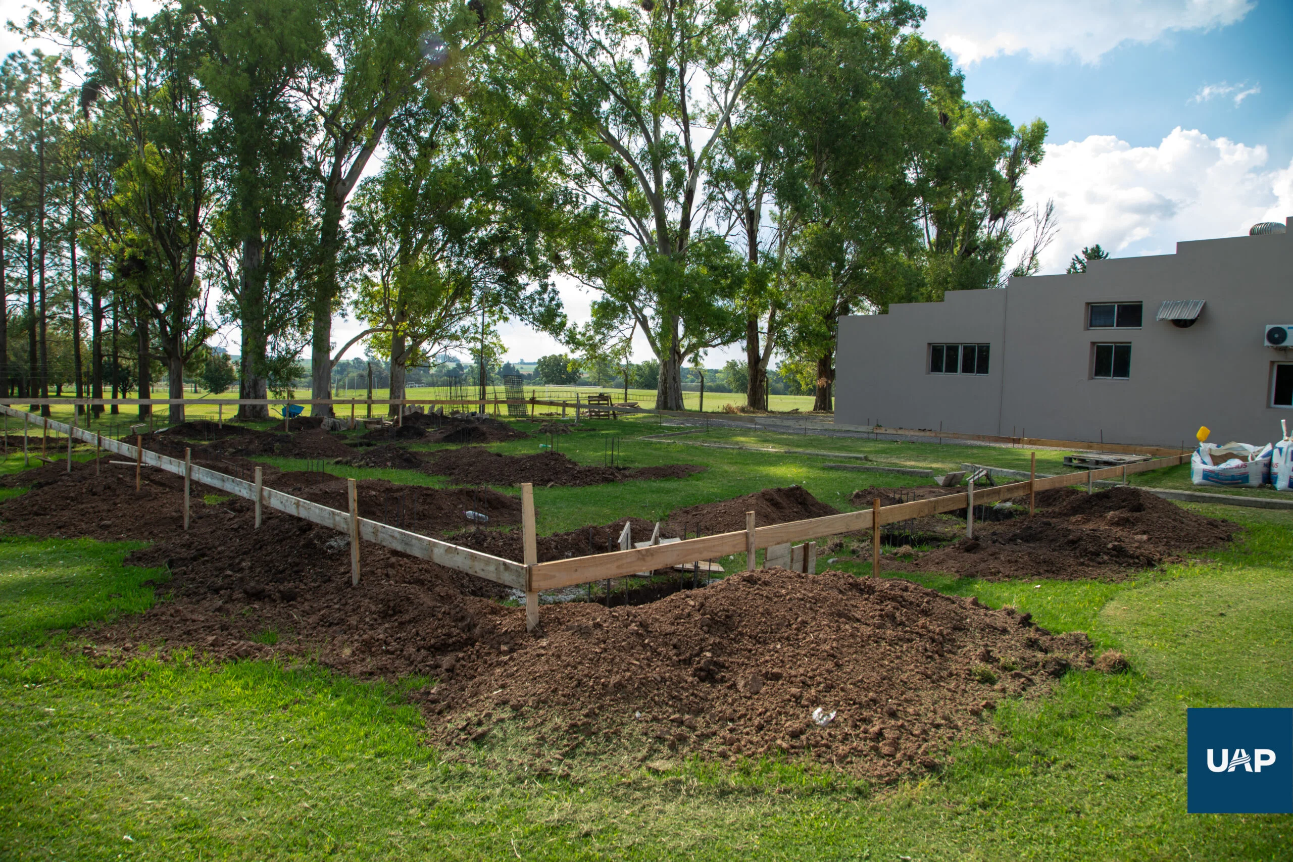 Vista del sitio de construcción con el campus de la UAP de fondo